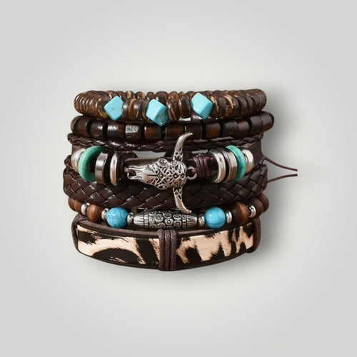 A stack of bohemian-style multi-strand bracelets on a light gray background. The bracelets feature dark brown leather cords, wooden beads, turquoise blue beads, green beads, silver-toned metal spacers, and a silver bull skull charm.