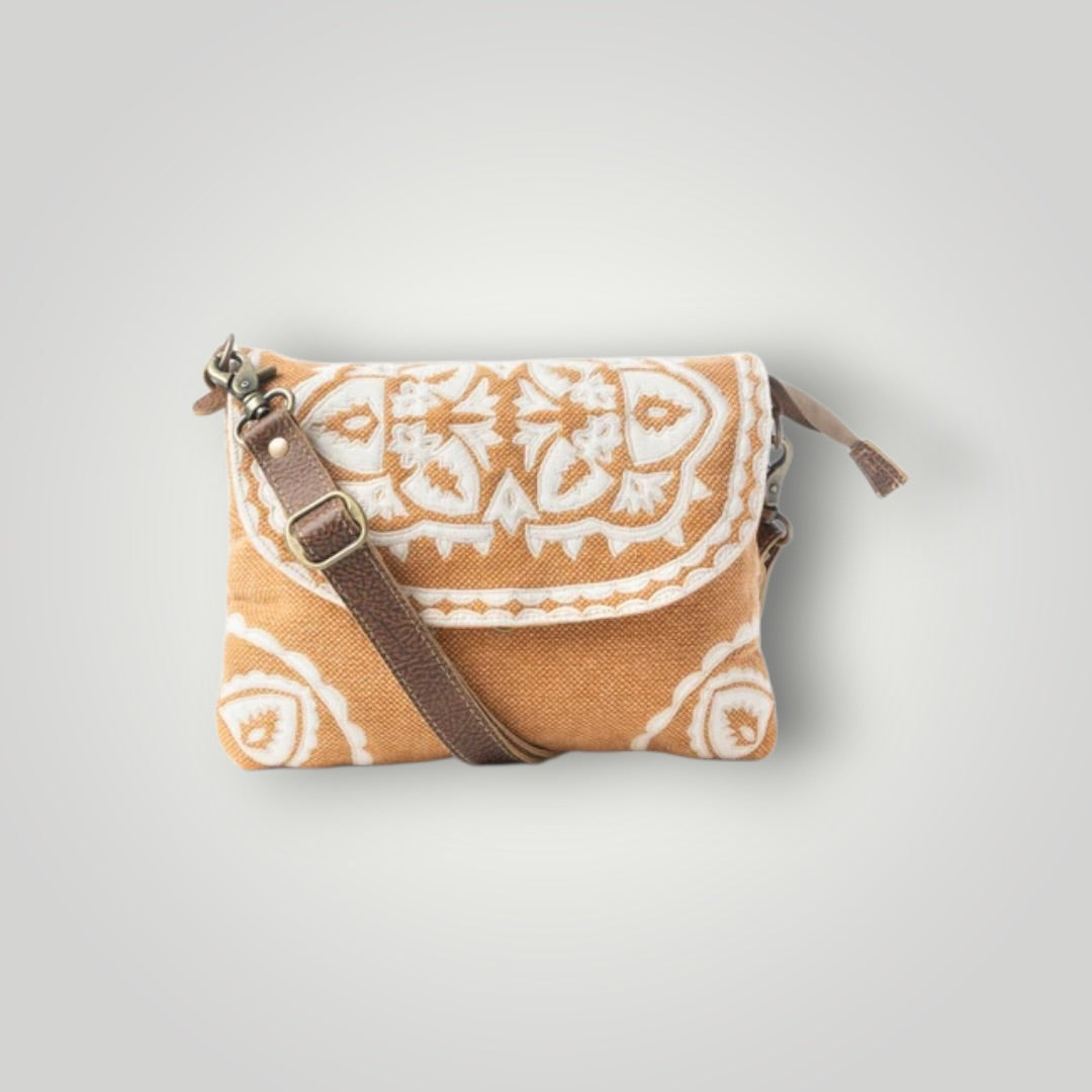 A small crossbody clutch bag with a brown woven patterned body, a brown leather strap, and a gold-tone buckle, shown on a light gray background.