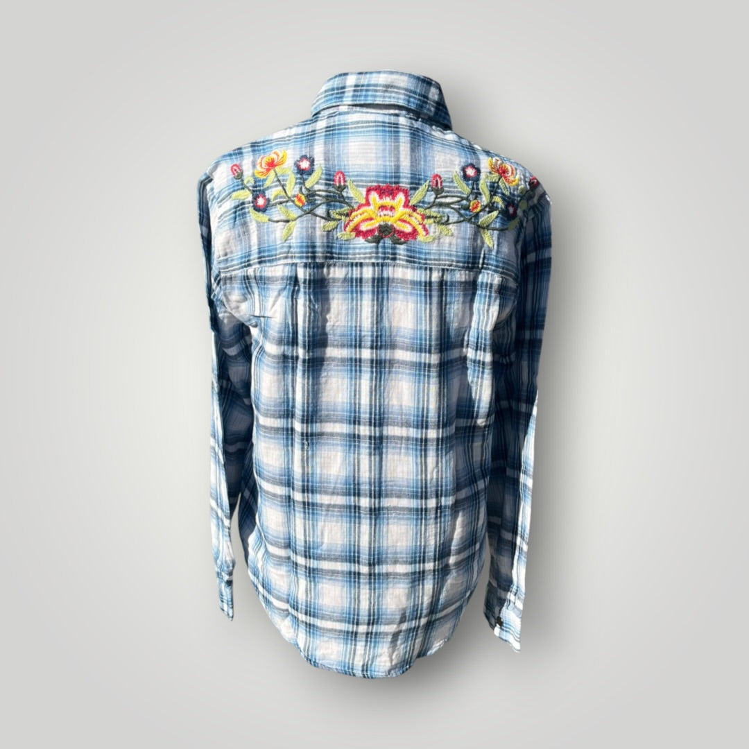 A blue and white plaid long-sleeve button-up shirt shown from the back, featuring a colorful embroidered floral design across the upper back.