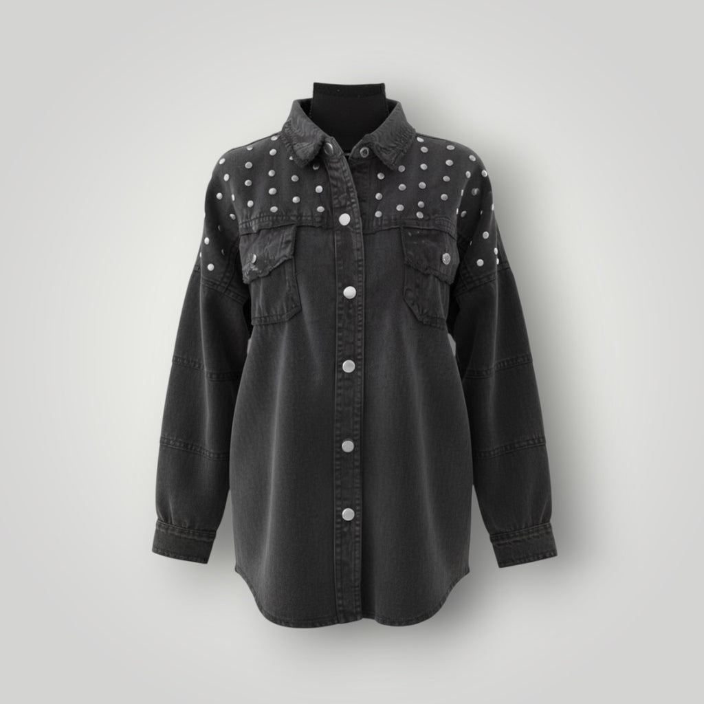 A black washed denim button-up shirt jacket with silver studs on the shoulders and chest, displayed on a black mannequin torso against a light gray background.