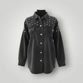 A black washed denim button-up shirt jacket with silver studs on the shoulders and chest, displayed on a black mannequin torso against a light gray background.