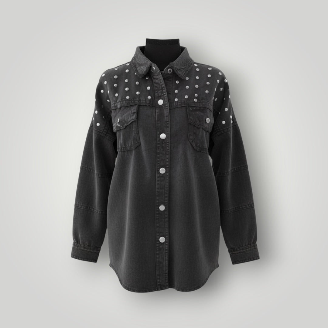 A black washed denim button-up shirt jacket with silver studs on the shoulders and chest, displayed on a black mannequin torso against a light gray background.